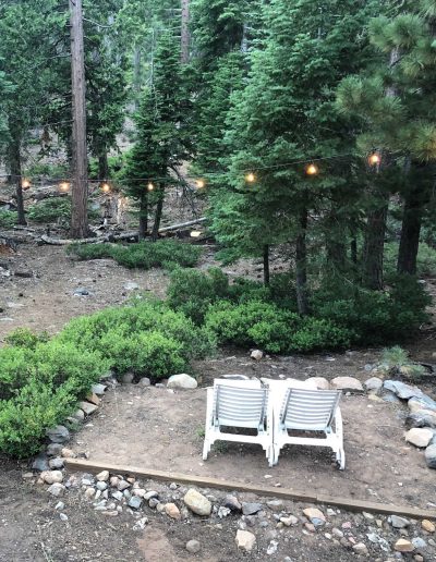 Outdoor seating area with lounge chairs and white lights